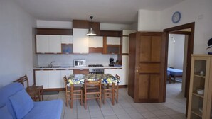 A compact living space with a kitchenette, a dining area, and a bedroom. - Holidays apartment in Limone sul Garda- first floor, right side (Limone Sul Garda)