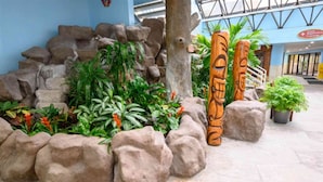 A tropical-themed indoor garden with rock formations and wooden sculptures. - New Direct Oceanfront,Heated Indoor Pool,Remodeled (Myrtle Beach)