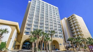 A high-rise hotel with multiple balconies, a central entrance, and palm trees in the foreground. - Amazing Views on High Floor at Beautiful Sea Mist (Myrtle Beach)
