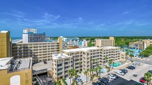 A multi-story hotel with a central courtyard, a swimming pool, and a view of the ocean. - Amazing Views on High Floor at Beautiful Sea Mist (Myrtle Beach)
