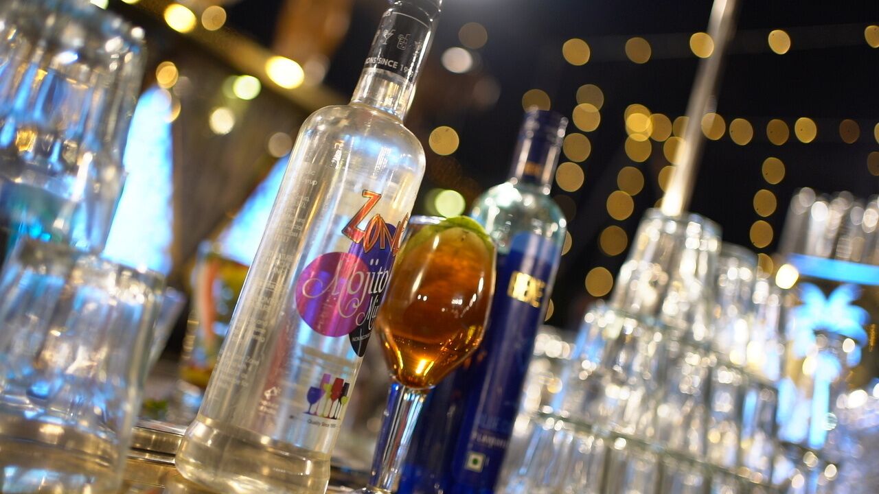 Un bar con diversas botellas y vasos.