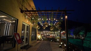 An outdoor patio area with hanging planters and string lights.