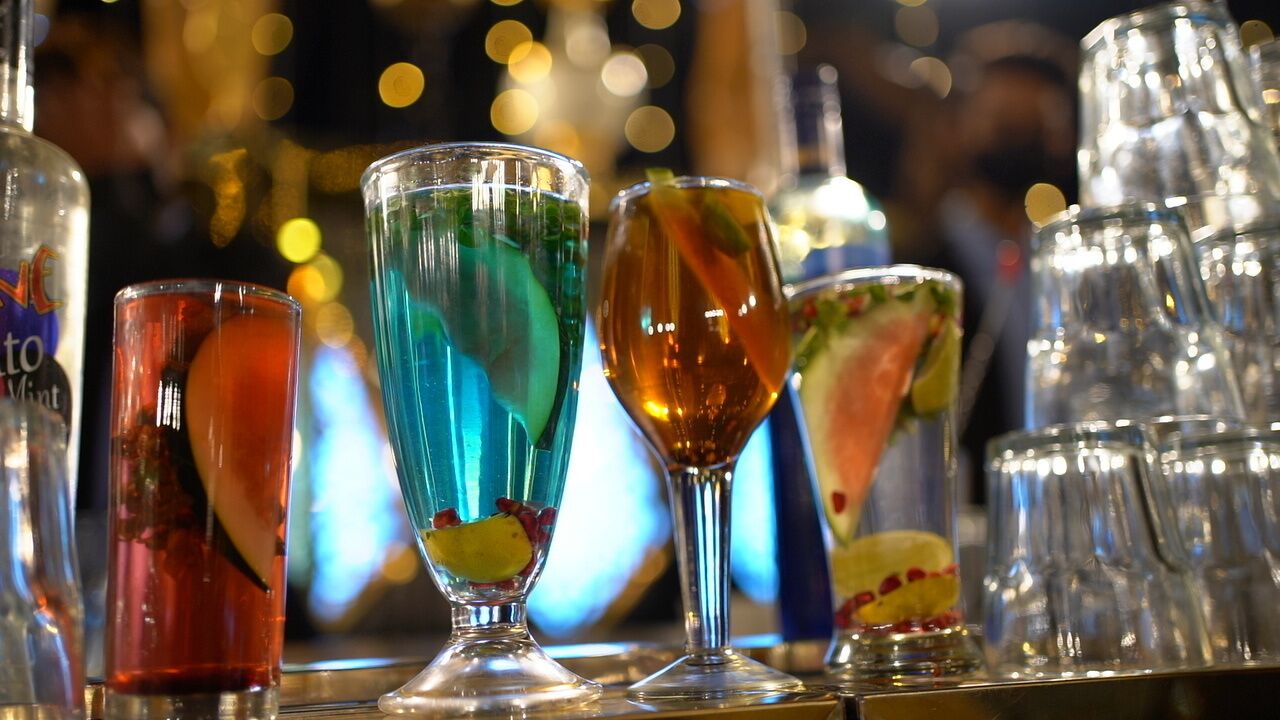 A bar with various colorful cocktails in glasses.