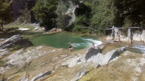 A natural hot spring surrounded by rocky terrain and dense forest. - Restored Watermill with Rock Pool and Waterfall (San Giustino)