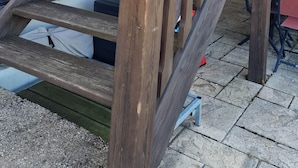 En trätrappa som leder upp till ett hus med ett fönster och en dörr.