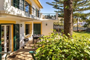 Un bâtiment à deux étages doté d’un balcon, d’un espace extérieur aménagé pour s’asseoir et d’un jardin bien entretenu.