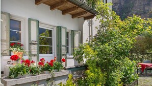 A building with a balcony, windows with shutters, and potted plants. - Apartment 'Villa Stanga' with Mountain View, Private Garden and Wi-Fi (Sedico)