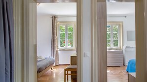A room with a bed, a desk, and a window with a view of greenery. - Apartment 'Villa Stanga' with Mountain View, Private Garden and Wi-Fi (Sedico)