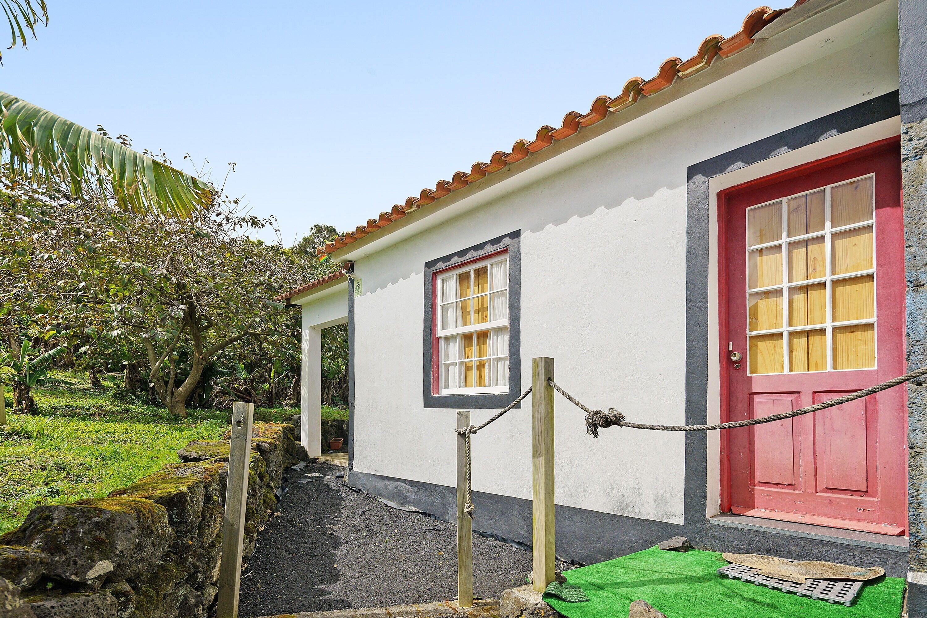 A building with a red door, a white wall, and a small window.