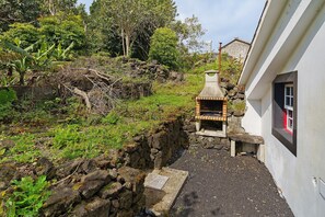 A stone wall, a small stone bench, and a chimney.