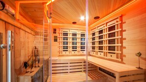 Un sauna avec des bancs en bois et une paroi en verre.