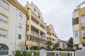 Un edificio residencial de varios pisos con balcones, una entrada con portón y un cartel que dice 'BIL WORLD'.