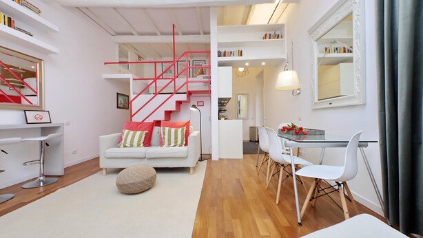 A modern living space with a staircase, white furniture, and bookshelves. - 4bnb - Serpenti Delightful Apartment (Rome)