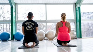 Two people on exercise mats in a room with large windows and exercise balls. - Village Club du Soleil de Montgenèvre (Montgenevre)