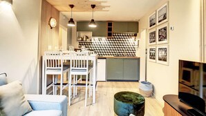 Uma sala de estar moderna com área de jantar, cozinha e unidade de entretenimento.