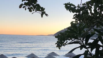 Relax on the beach with comfortable sun loungers and shaded umbrellas.