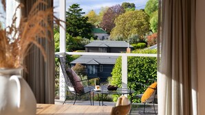A balcony with a table and chairs, a view of a house, and a vase with dried plants. - Stockton House- light-filled retreat with art and unique flair (Daylesford)