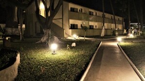 A building with multiple windows and a pathway leading to it.