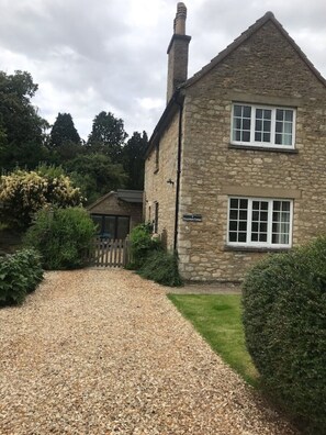 A stone building with a gravel driveway leading to a wooden gate. - Central Modern open plan house 3 ensuite bedrooms, dog friendly. (Helmsley)