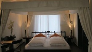 A bedroom with a canopy bed, a desk, and a chair. - Seagull house, beach, bathing jetty, boat mooring on Lake Plau (Alt Schwerin)