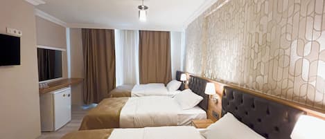A hotel room with two beds, a small kitchenette, a television, and a decorative wall.
