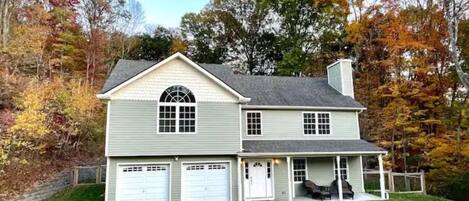 A two-story house with a garage, a covered porch, and a driveway.
