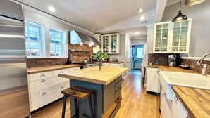 Una cocina moderna con una isla central, electrodomésticos de acero inoxidable y piso de madera.