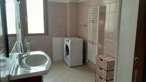 A compact bathroom with a sink, a washing machine, and a towel rack. - Panorama Apartment (Intimate, up to 3 people) (Muravera)