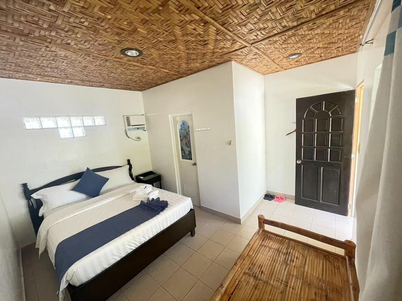 A room with a bed, a door, and a window.