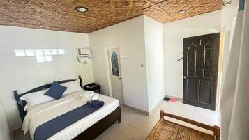 A room with a bed, a door, and a window.