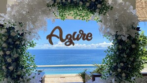 An outdoor area with a view of the sea, a decorative arch with the word "Azule" in the center, and a tiled pathway leading to the water. - azure camotes resort hotel (San Francisco)
