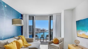 A modern living room with a city view, a large window, and a blue wall with a map design.