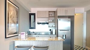 A modern kitchen with a central island, bar stools, a refrigerator, and a tiled floor. - w* | Bright Loft in Santa Ana w/ AC (Panamá)