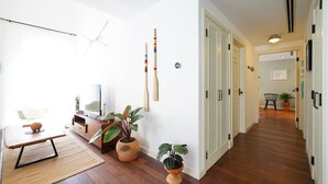 Un salon moderne avec un plancher en bois, une table à manger, un canapé et des plantes en pot.