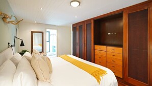 Une chambre à coucher avec un grand lit, une armoire en bois et un petit bureau avec une lampe.