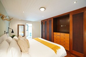 Ein Schlafzimmer mit einem großen Bett, einem Holzschrank und einer hellen Decke.