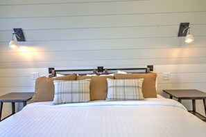 Ein Hotelzimmer mit einem großen Bett, zwei Nachttischen und Wandlampen.