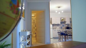 A kitchen with a dining area, a white table, and chairs. - Midway House Apartment with free internal parking (Sant'Egidio del Monte Albino)