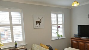 Una sala de estar con sofá, mesa de centro, televisor y chimenea.