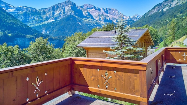 A wooden balcony with a mountain view, overlooking a small wooden cabin and a lake. - Family chalet overlooking the Midi Teeth (Champéry)