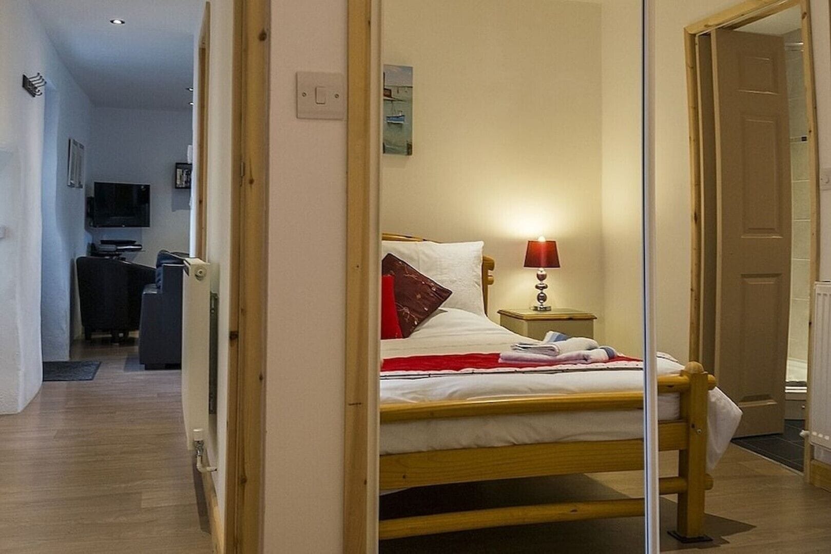 Ein Schlafzimmer mit Bett, Nachttisch, Lampe und einem Bild an der Wand.