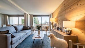 Een moderne woonkamer met een grijze bank, een witte salontafel en een pluizige witte schaap-beeldje.