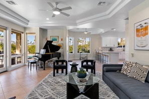 A spacious living area with a grand piano, a sofa, and a coffee table.