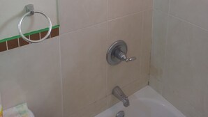 A bathroom with a shower, a toilet, and a bathtub. - Cheerful 2-Bedroom Home in Falmouth Garden (Falmouth)