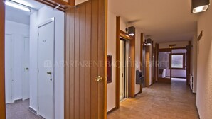 Un pasillo con puertas de madera, suelo de baldosas y una puerta identificada con la etiqueta 'CP'.