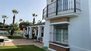 A two-story building with a balcony, a covered patio area, and a pool. - 5star A/C villa, 5 min beach & marina w bars refurb. pool & garden.  (Cadiz)