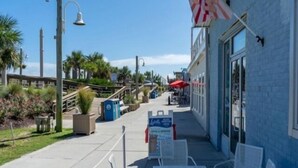 Eine Uferpromenade mit Außenbereich, ein Schild für 'Lululemon' und ein Gebäude mit blauer Fassade.