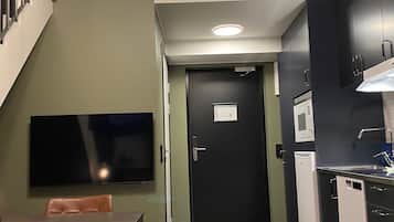 Een moderne keuken met een magnetron, spoelbak en een eethoek met een tafel en stoelen.