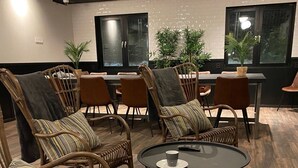 A room with wicker chairs, a round table, and potted plants.