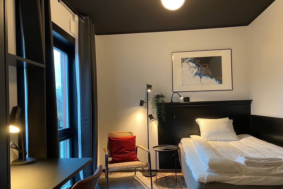 A modern bedroom with a bed, a desk, and a chair.